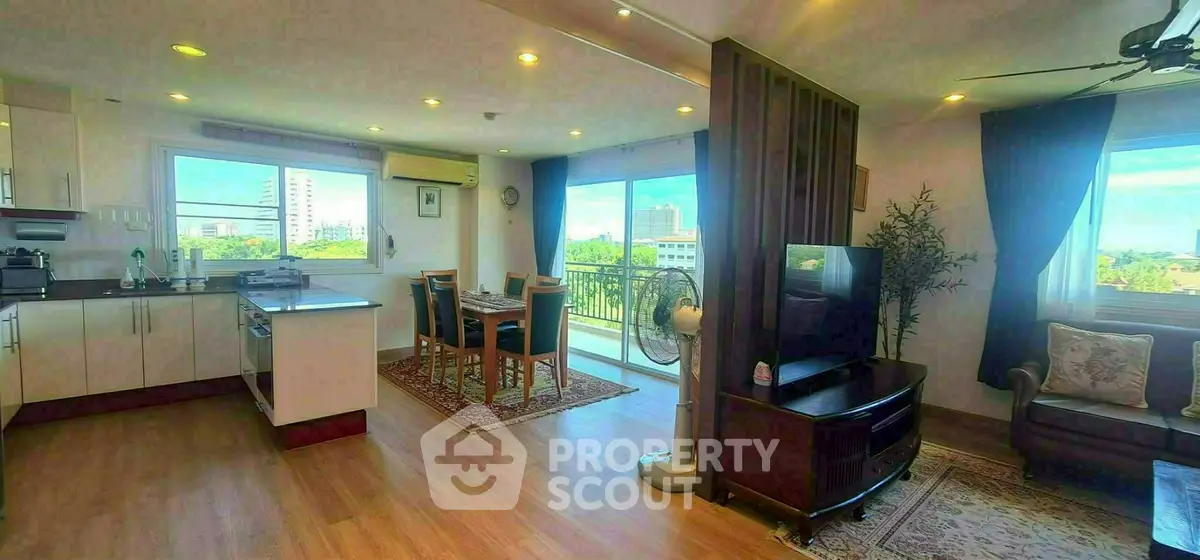 Spacious open-plan living room with dining area and balcony view