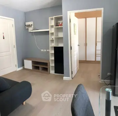 Modern living room with sleek furniture and open doorway to bedroom