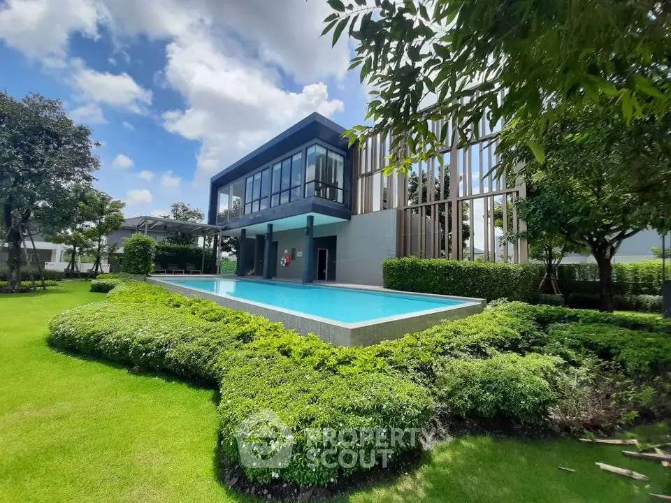 Modern luxury home with private pool and lush garden under blue sky