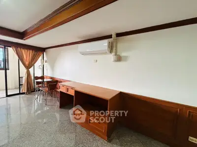 Spacious living area with modern air conditioning and elegant wooden furniture