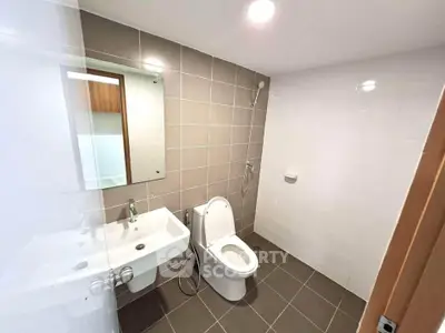 Modern bathroom with sleek fixtures and neutral tiles, perfect for a contemporary home.