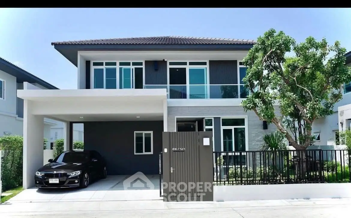Modern two-story house with sleek design and spacious driveway in a serene neighborhood.