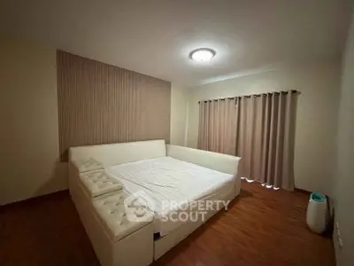 Spacious bedroom with elegant design and cozy ambiance, featuring a large bed and stylish decor.
