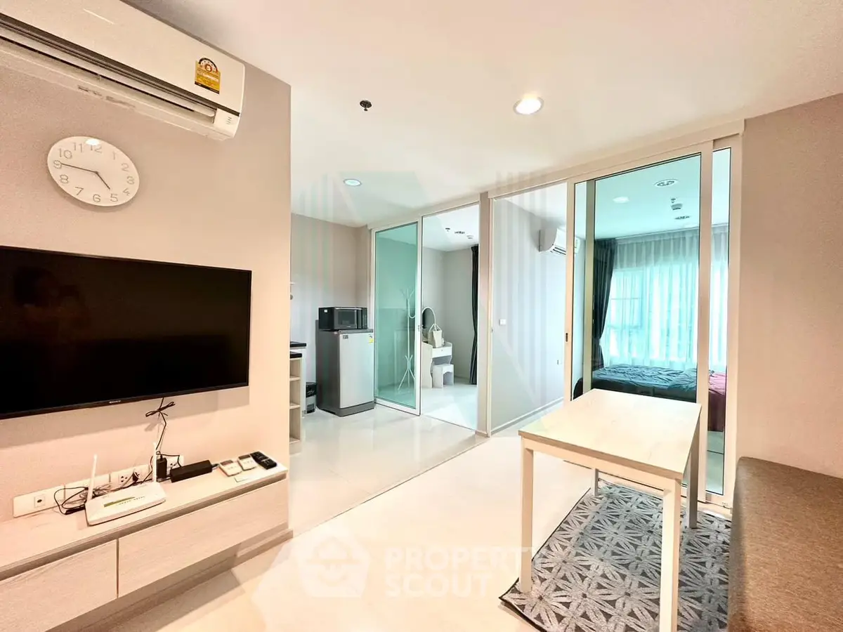 Modern apartment interior with open layout, featuring a cozy living area, sleek kitchen, and bright bedroom.