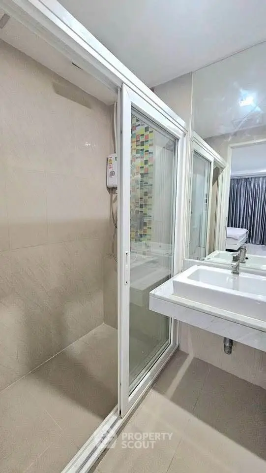 Modern bathroom with glass shower enclosure and sleek double sink vanity.