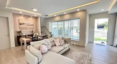 Spacious modern living room with elegant dining area and large windows.