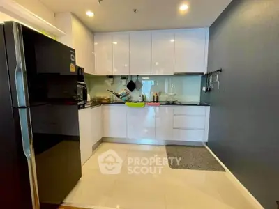 Modern kitchen with sleek white cabinets and black appliances in a stylish apartment.