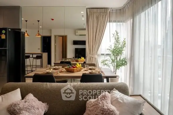 Modern living room with dining area and large windows in a stylish apartment.