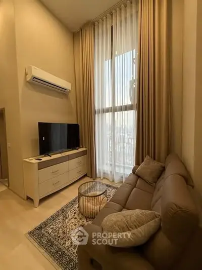 Cozy living room with high ceilings, large window, and modern furnishings in a stylish apartment.