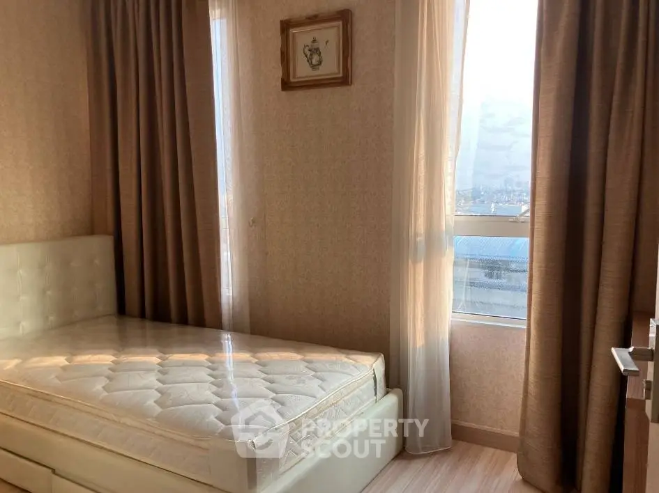 Cozy bedroom with natural light and elegant curtains in a modern apartment.