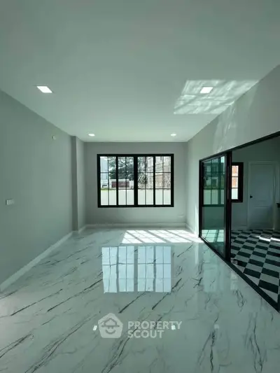 Spacious modern living room with marble flooring and large windows for natural light.