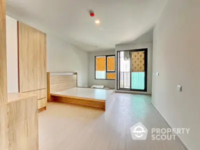 Spacious modern bedroom with wooden flooring and large windows in a minimalist design.