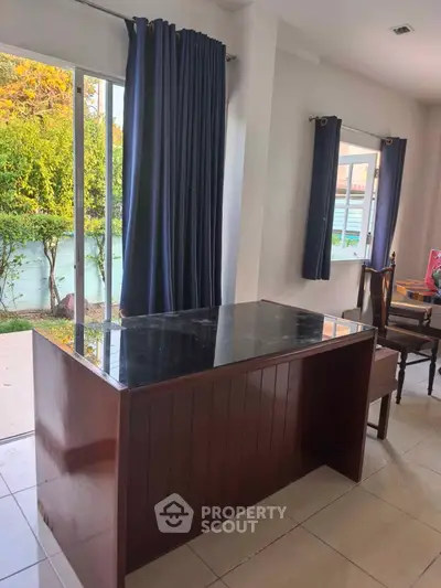 Spacious dining area with elegant marble table and garden view, perfect for family gatherings.