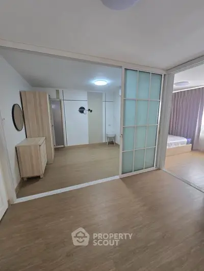 Spacious modern bedroom with sliding glass doors and wooden flooring