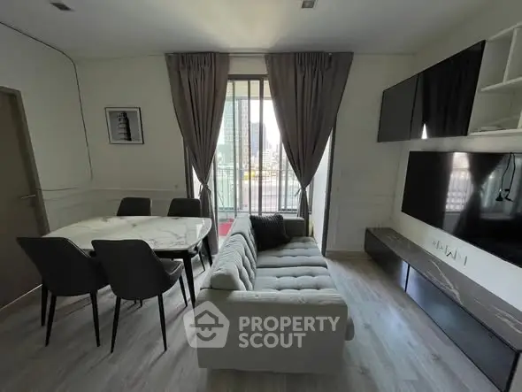 Modern living room with stylish furniture and city view from large window.