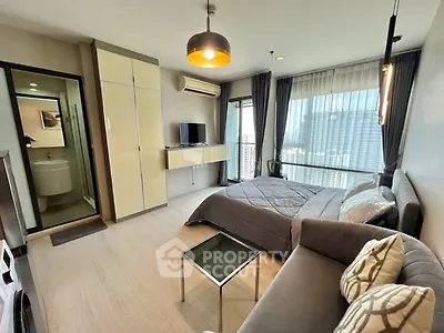 Modern bedroom with city view, cozy sofa, and sleek decor in high-rise apartment.