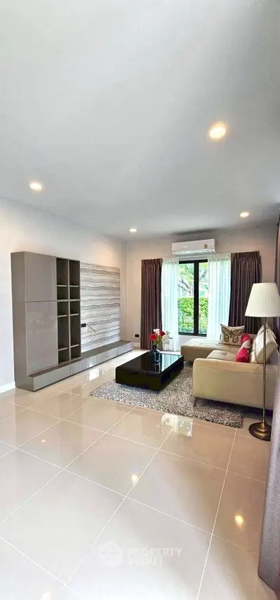 Spacious modern living room with elegant decor and large window view.