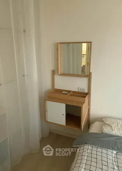 Cozy bedroom corner with modern wooden vanity and mirror, perfect for minimalist living.