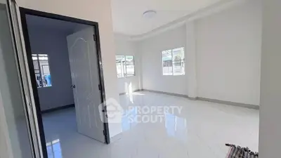 Bright and spacious interior with modern white tile flooring and ample natural light.