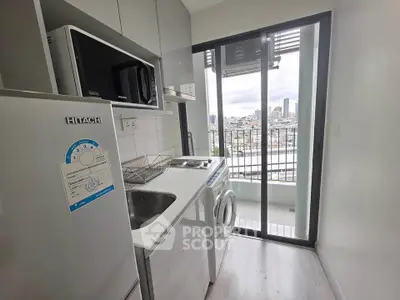 Modern compact kitchen with city view, featuring sleek appliances and a washing machine, ideal for urban living.
