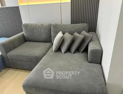 Modern living room with stylish gray sectional sofa and decorative pillows.