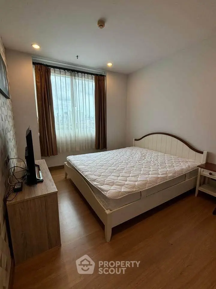 Cozy bedroom with natural light, featuring a comfortable bed and modern decor, perfect for relaxation.