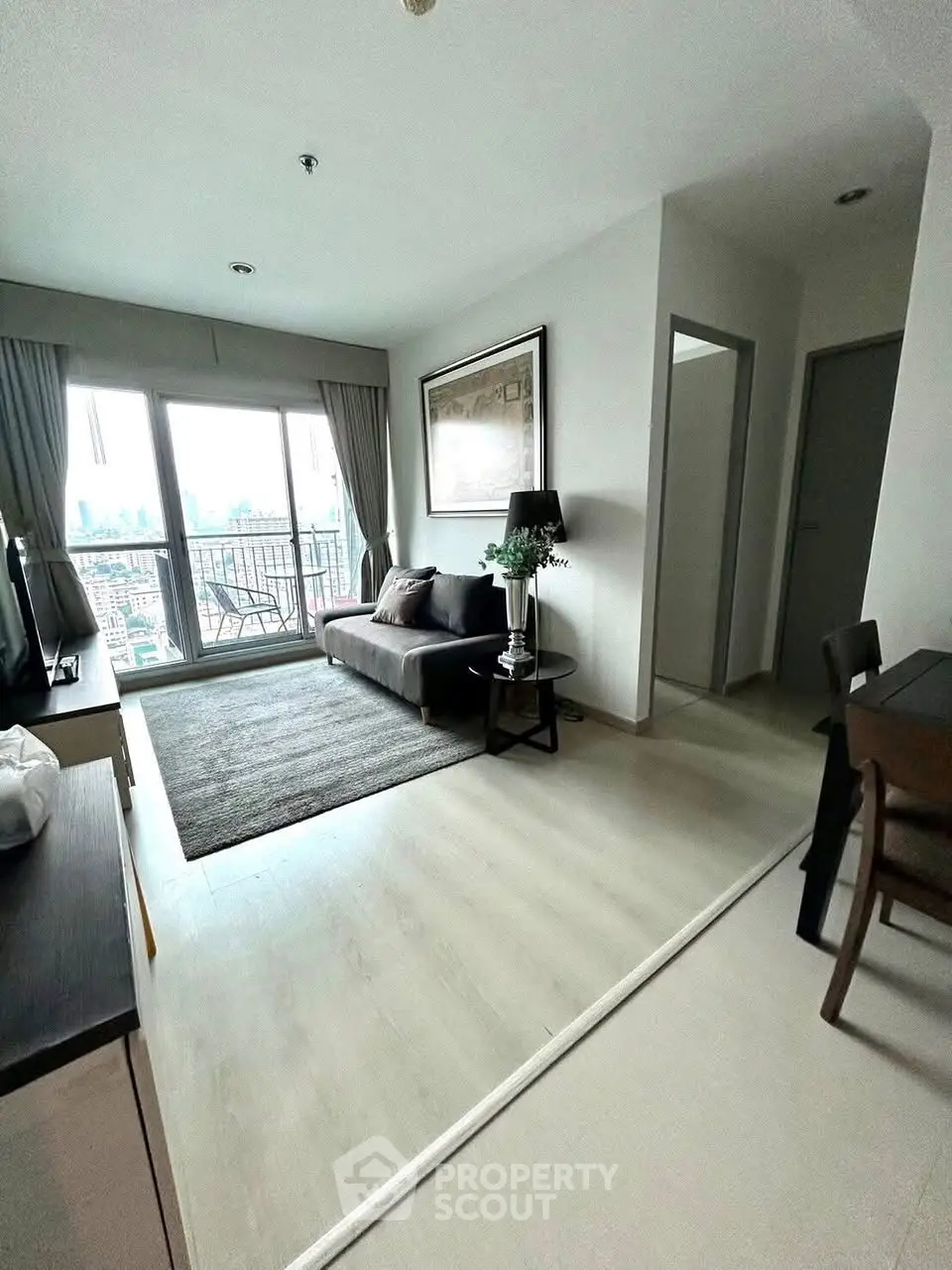 Modern living room with city view, stylish decor, and natural light.