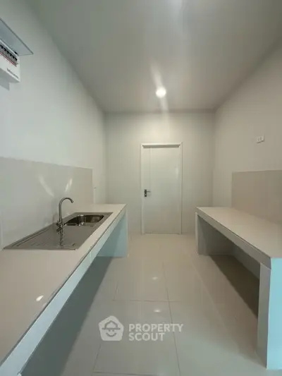 Minimalist kitchen with sleek countertops and modern sink in a compact layout.