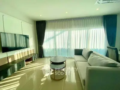 Spacious modern living room with large windows and elegant furnishings