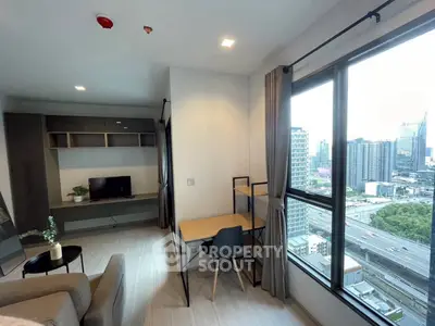 Modern living room with city view, featuring sleek furniture and large windows for natural light.