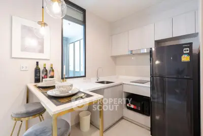 Modern kitchen with sleek appliances and stylish dining area in a contemporary apartment.
