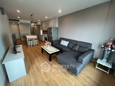 Modern open-plan living room with stylish furniture and kitchen area