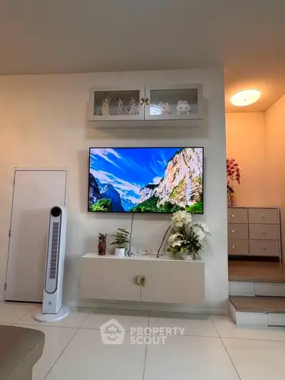 Modern living room with wall-mounted TV and elegant decor, showcasing a stylish and inviting atmosphere.