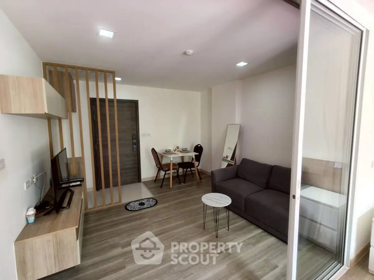 Modern living room with sleek furniture and open layout, featuring a cozy dining area and stylish decor.