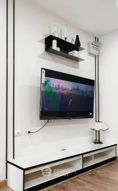 Modern living room with wall-mounted TV and sleek shelving unit.