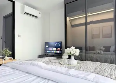 Modern bedroom with sleek design, featuring a cozy bed, TV, and stylish decor.