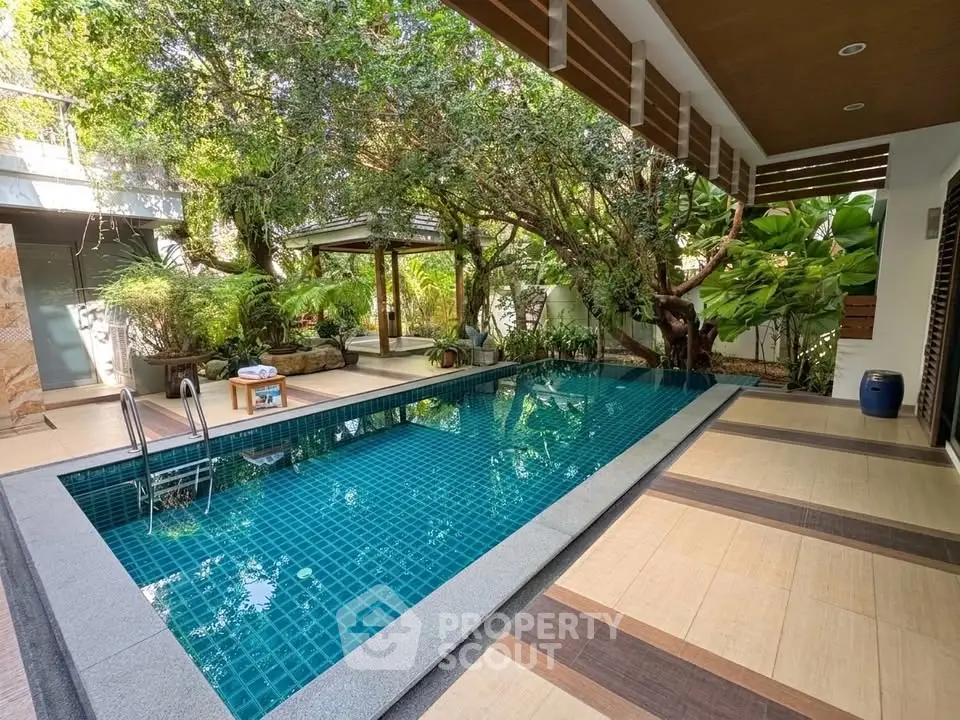 Luxurious private pool surrounded by lush greenery and modern architecture, perfect for relaxation and entertainment.