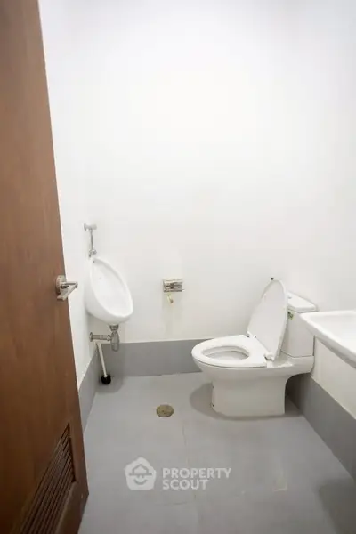 Minimalist bathroom with toilet and urinal in a compact space