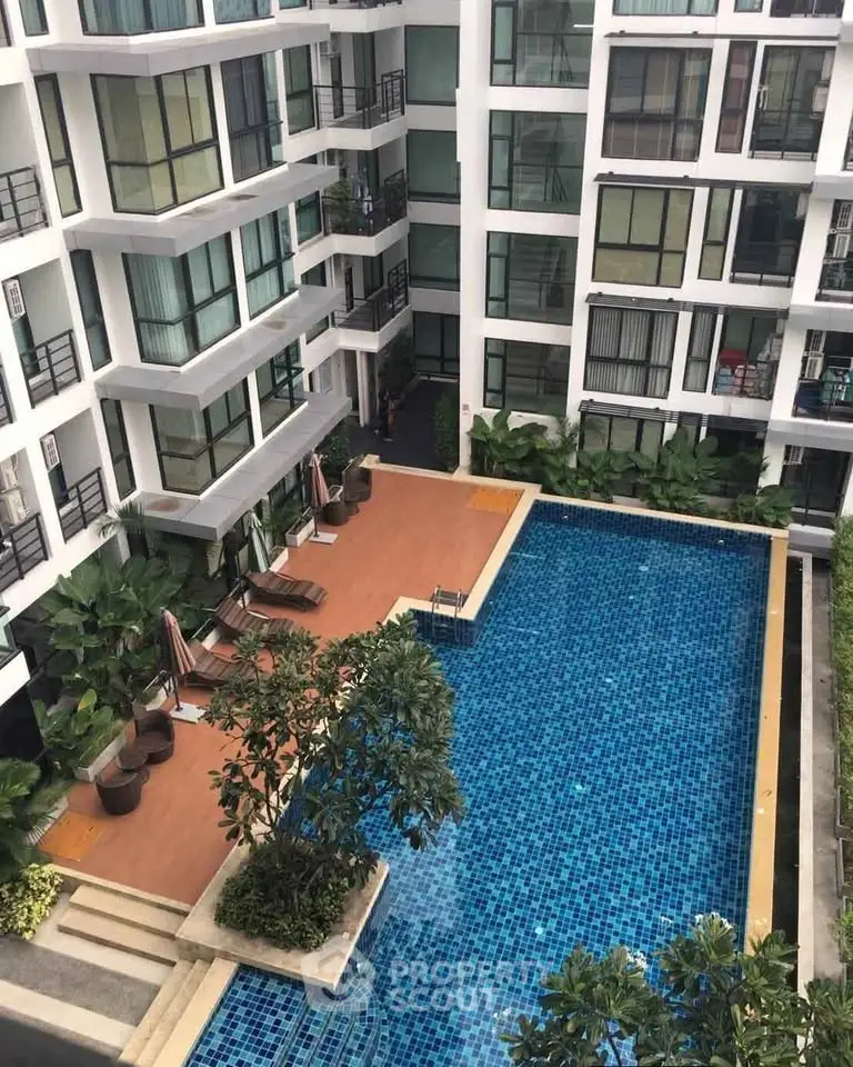 Modern apartment complex with a stunning outdoor pool and lush greenery, perfect for relaxation and leisure.