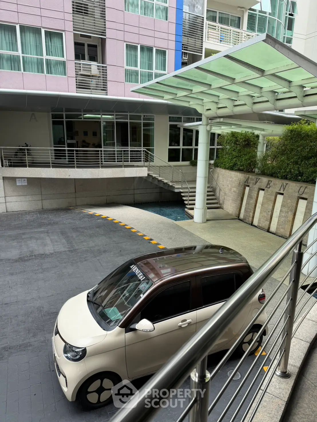 Modern apartment building entrance with sleek design and covered driveway