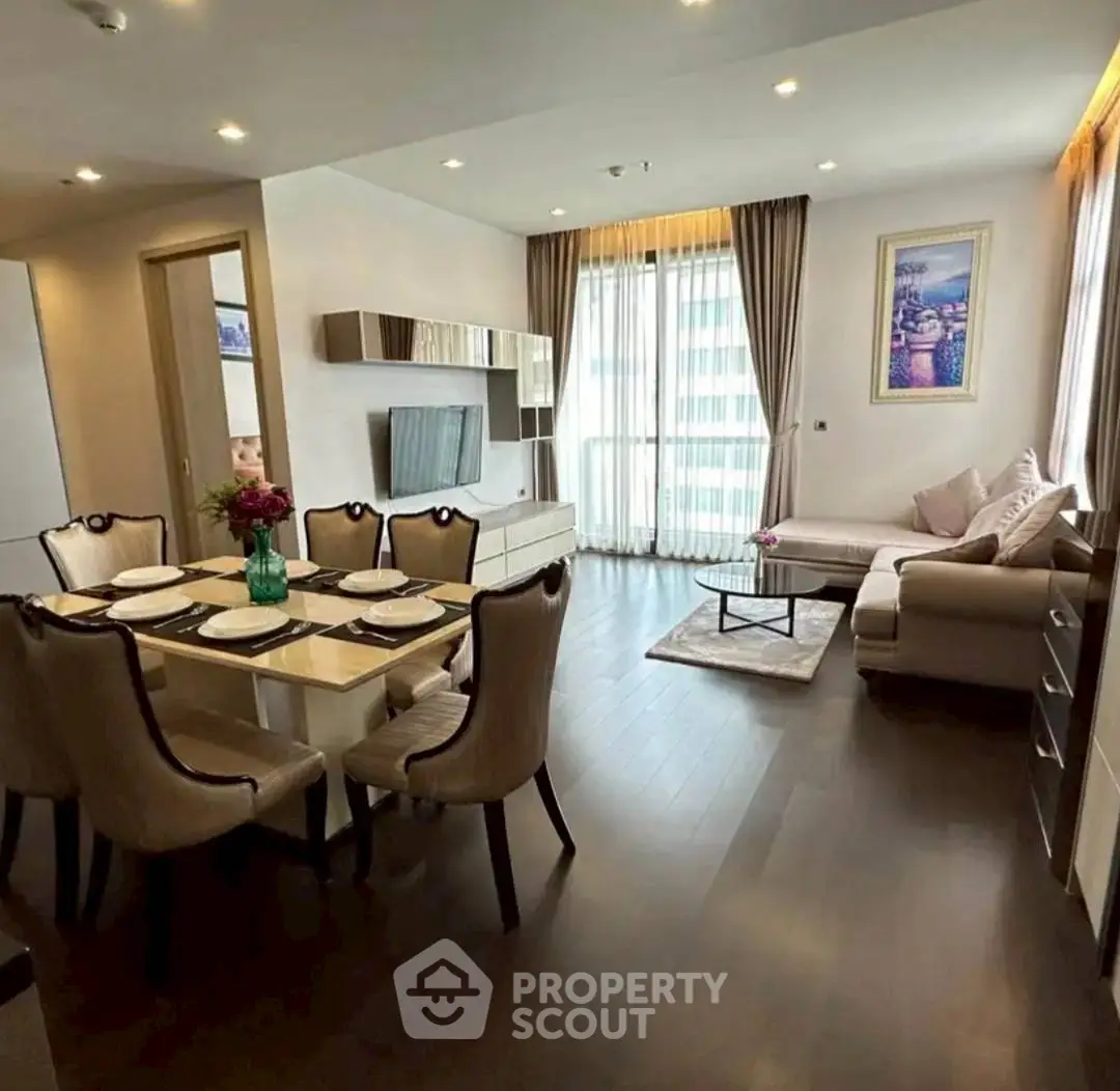 Elegant living room with dining area, modern decor, and natural light in a stylish apartment.