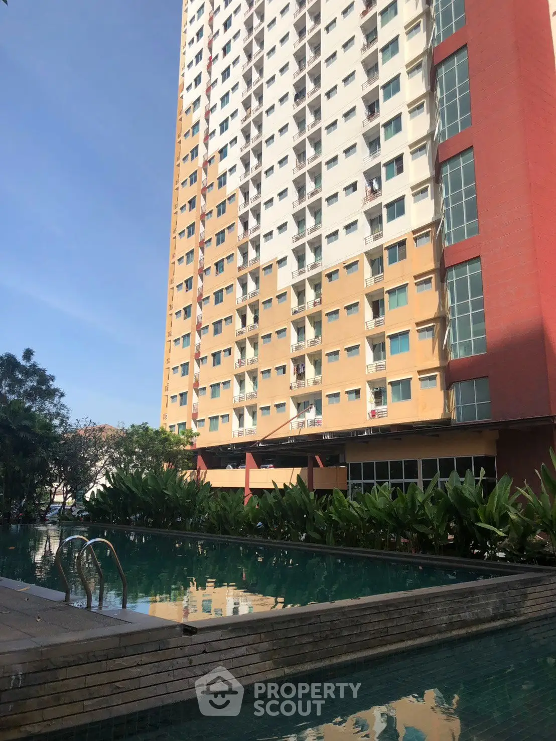 Modern high-rise apartment with pool and lush greenery, perfect for urban living.