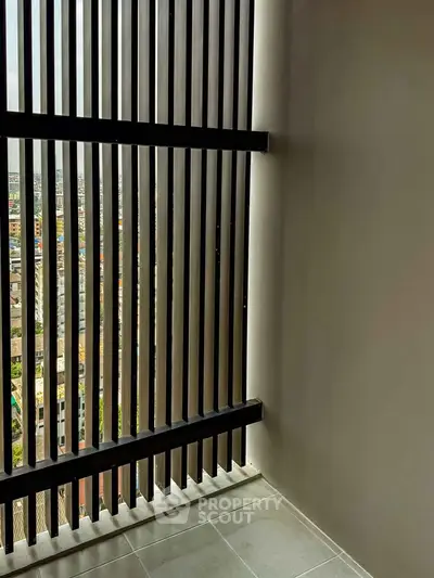 Modern balcony with city view through vertical slats, offering privacy and style.