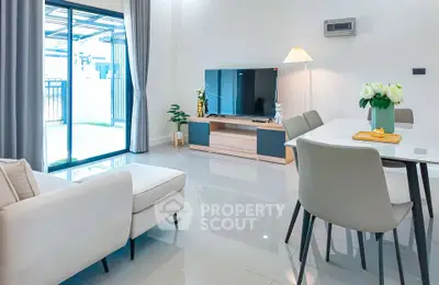 Modern living room with sleek furniture and large sliding glass doors leading to a patio.