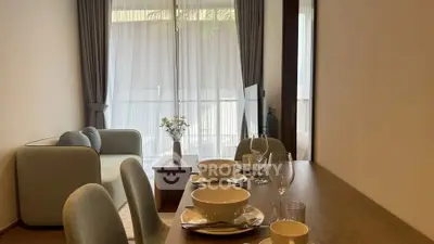 Modern living room with dining area and balcony view, featuring elegant decor and natural light.