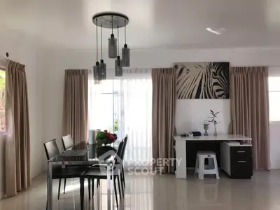 Spacious dining area with modern decor and natural light, perfect for family gatherings.