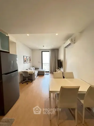 Modern living room with dining area and air conditioning in a stylish apartment.