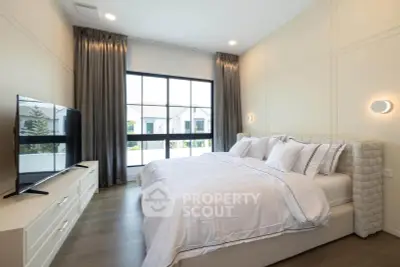 Luxurious bedroom with large window and modern decor in a stylish home.