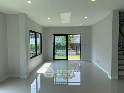 Spacious modern living room with large windows and glossy tile flooring