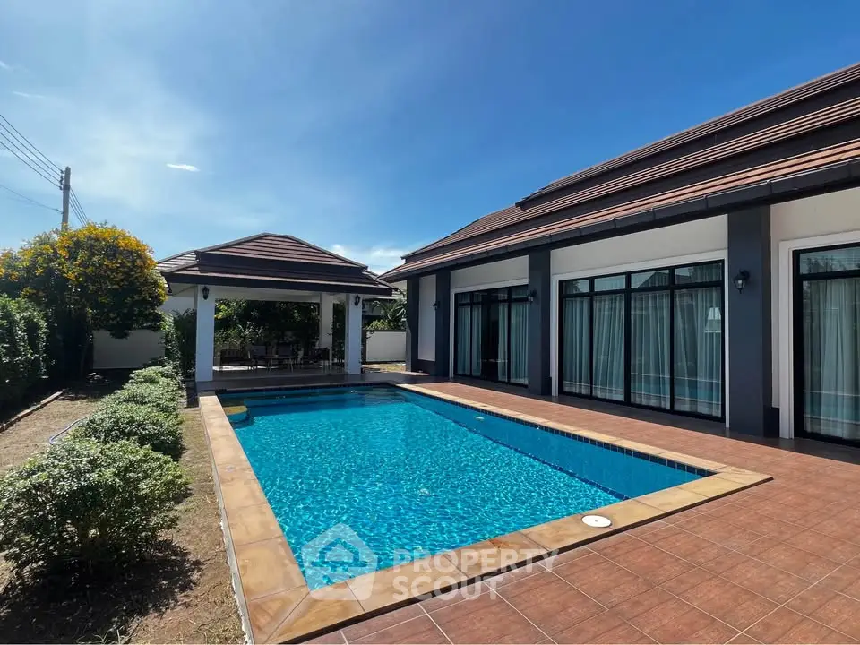 Luxurious villa with private pool and spacious patio under clear blue sky.